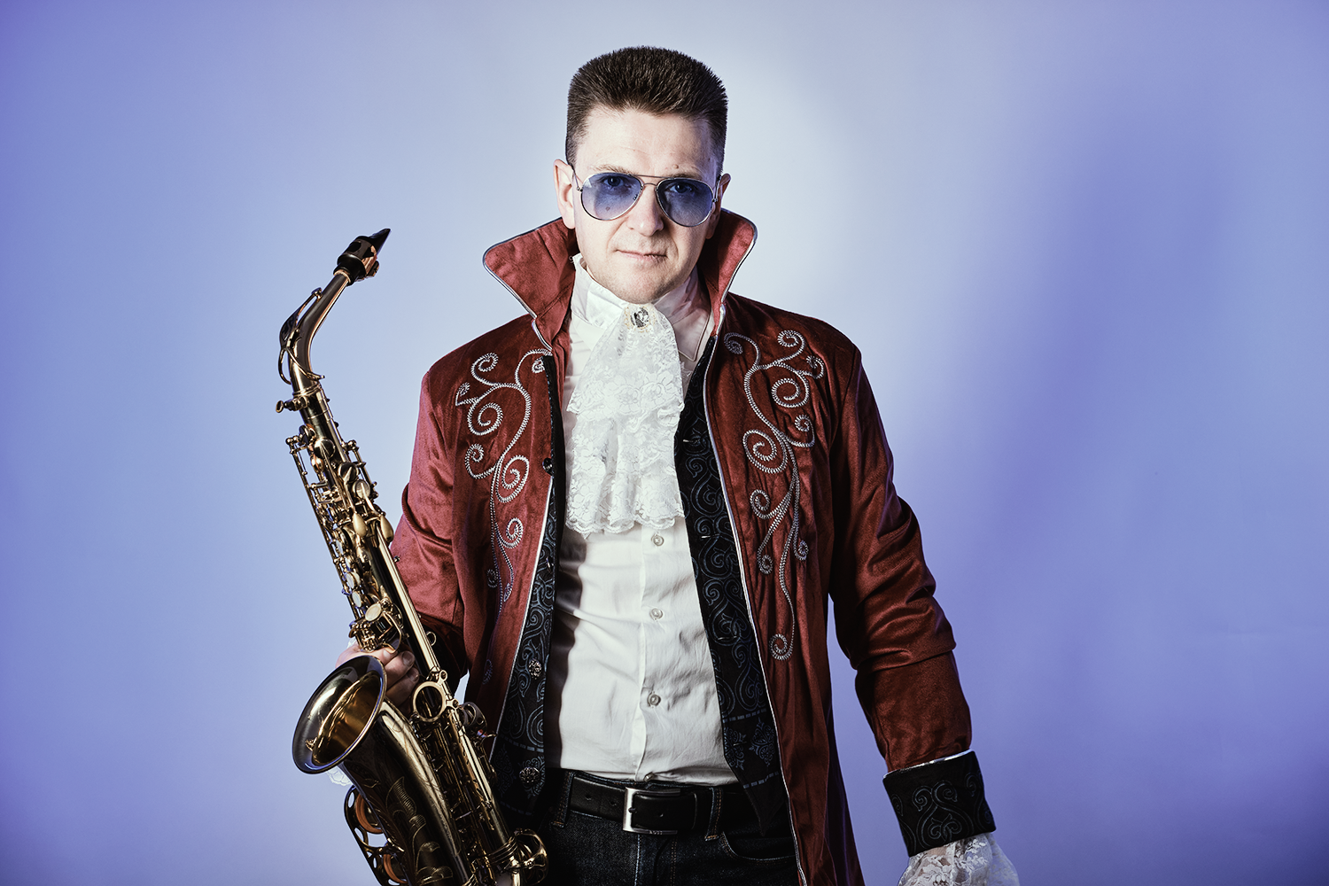 Viktor mit Sonnenbrille und Kostüm hält Saxophon in der rechten Hand